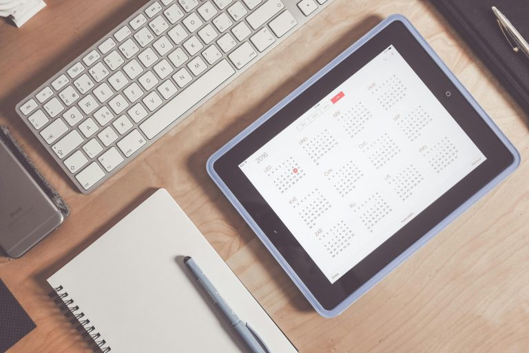 Escritorio ordenado con tablet y agenda para que organiza tu semana de forma eficiente