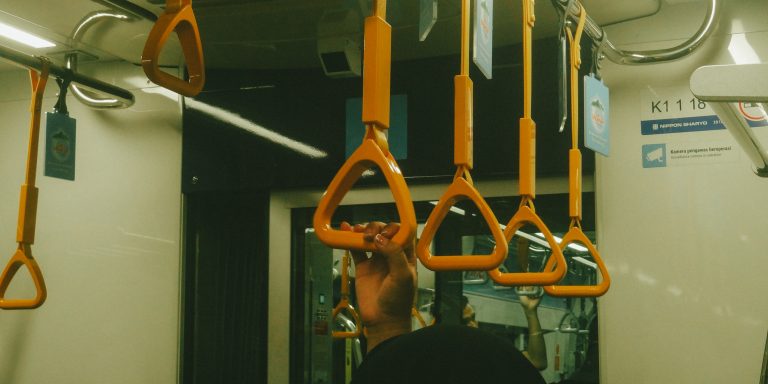 En trasporte publico sale una mano sujetándose de pasamano