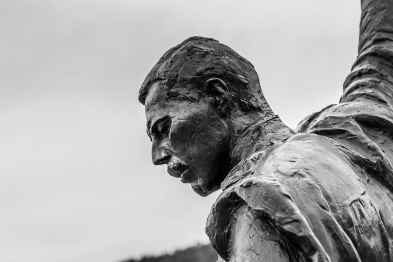 Una estatua de Freddy Mercury con un fondo nublado.
