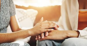 Dos personas cogidas de la mano ayudando una a otra