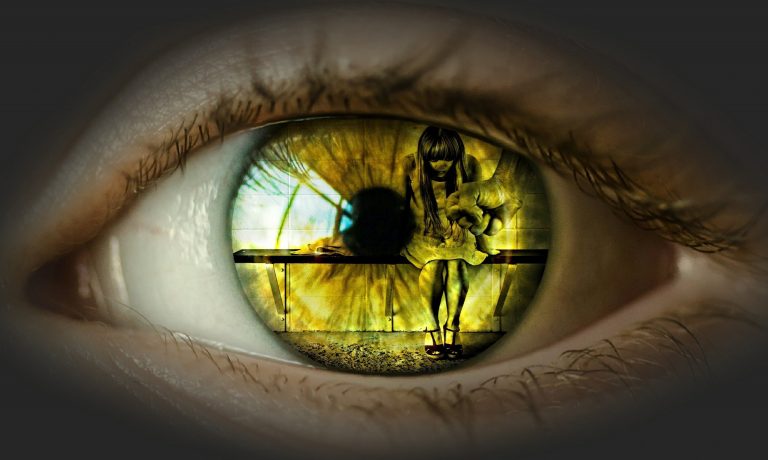 Primer plano de un ojo humano en el que se refleja una escena de violencia psicológica, con una persona intimidando a otra sentada, simbolizando abuso y maltrato invisible.